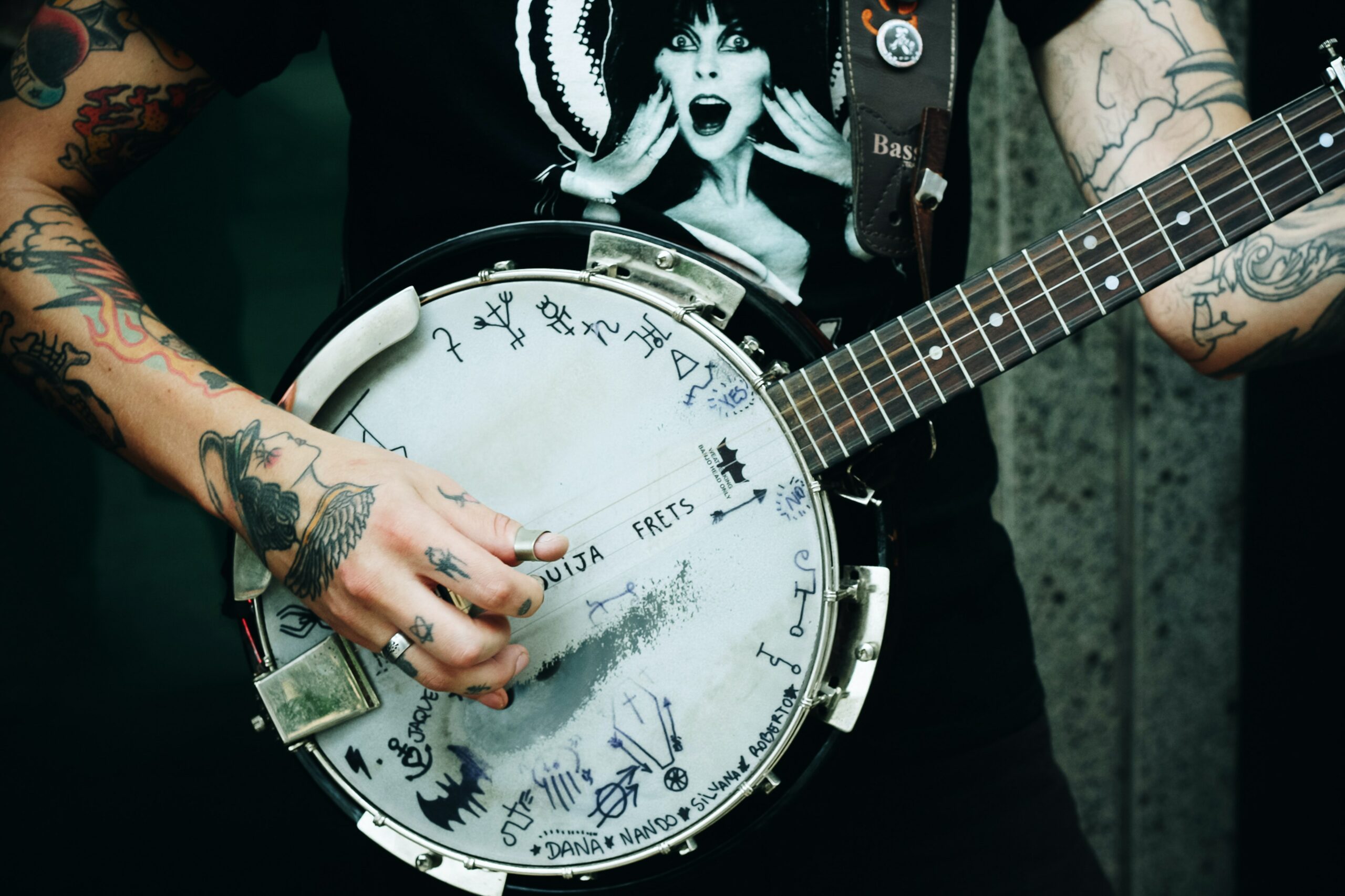 personne tatouée jouant du banjo